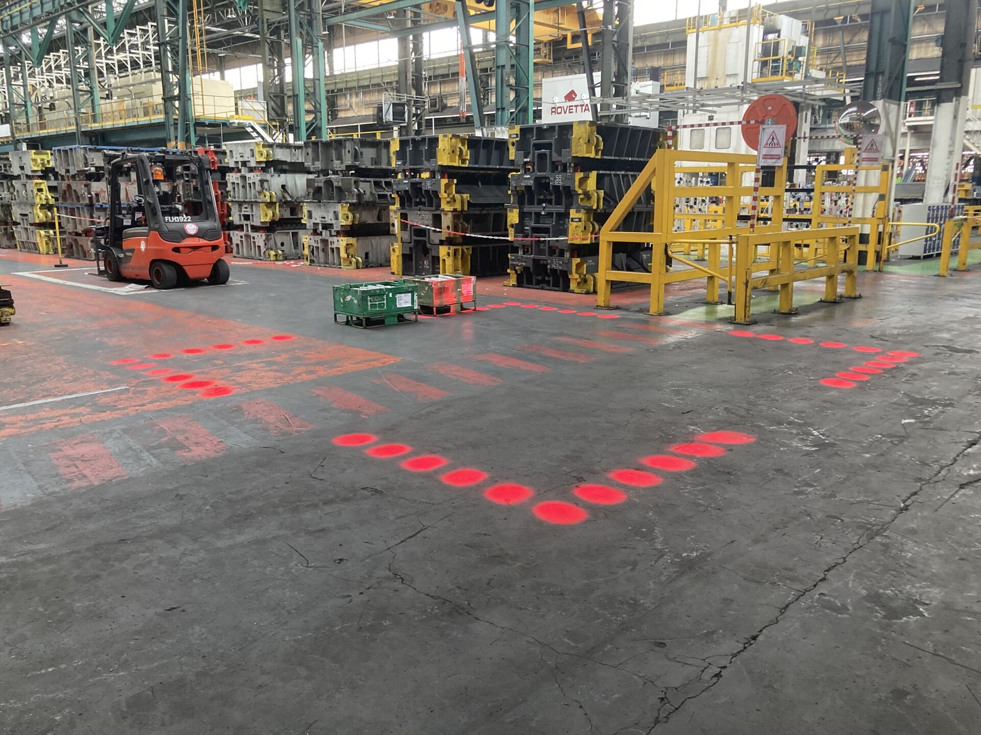 Marquage au sol de s&eacute;curit&eacute; compos&eacute; de points LED rouges d&eacute;limitant une zone de danger pr&egrave;s d'un chariot &eacute;l&eacute;vateur dans une usine.